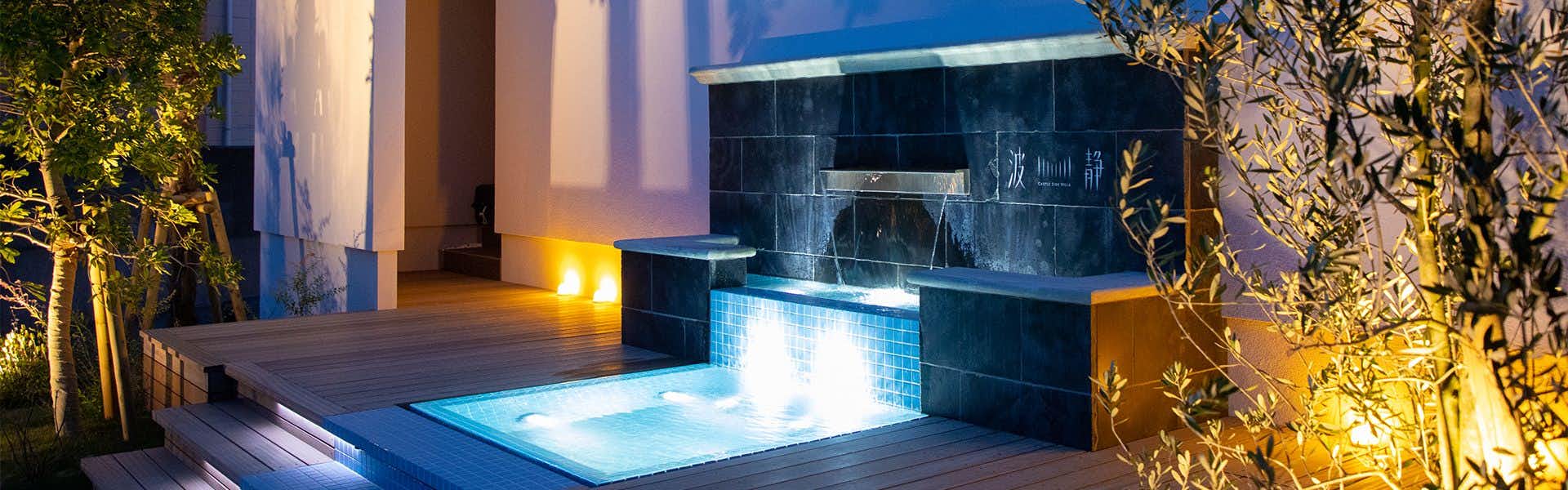 Mizuno Ryokan with a private waterfall pool glowing beside garden planting.