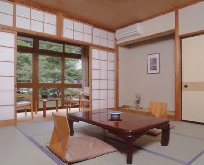 A traditional tatami room with low table and garden windows.