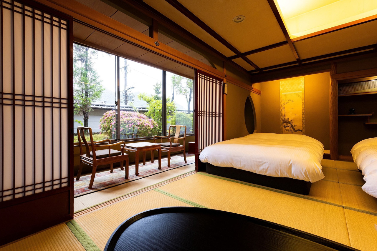 A tatami room combines low bedding with a garden view.