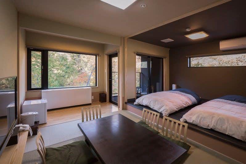 Marukiya Ryokan with a contemporary twin room with tatami seating and forest windows.