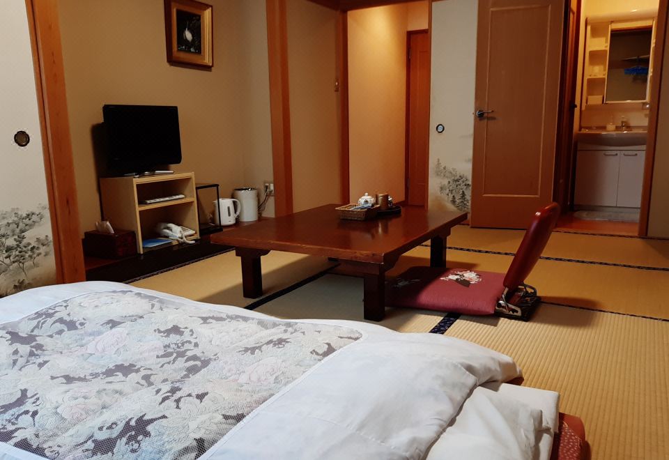 A Japanese guest room with bedding and a low table.