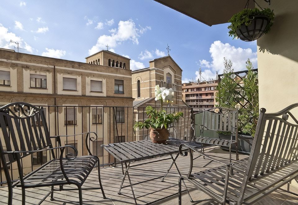 A balcony with chairs overlooking nearby buildings.