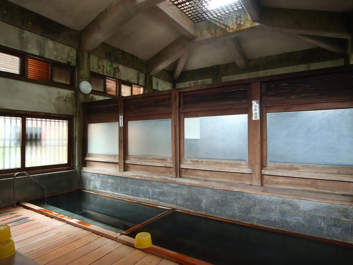 A traditional bath with a wooden water spout.