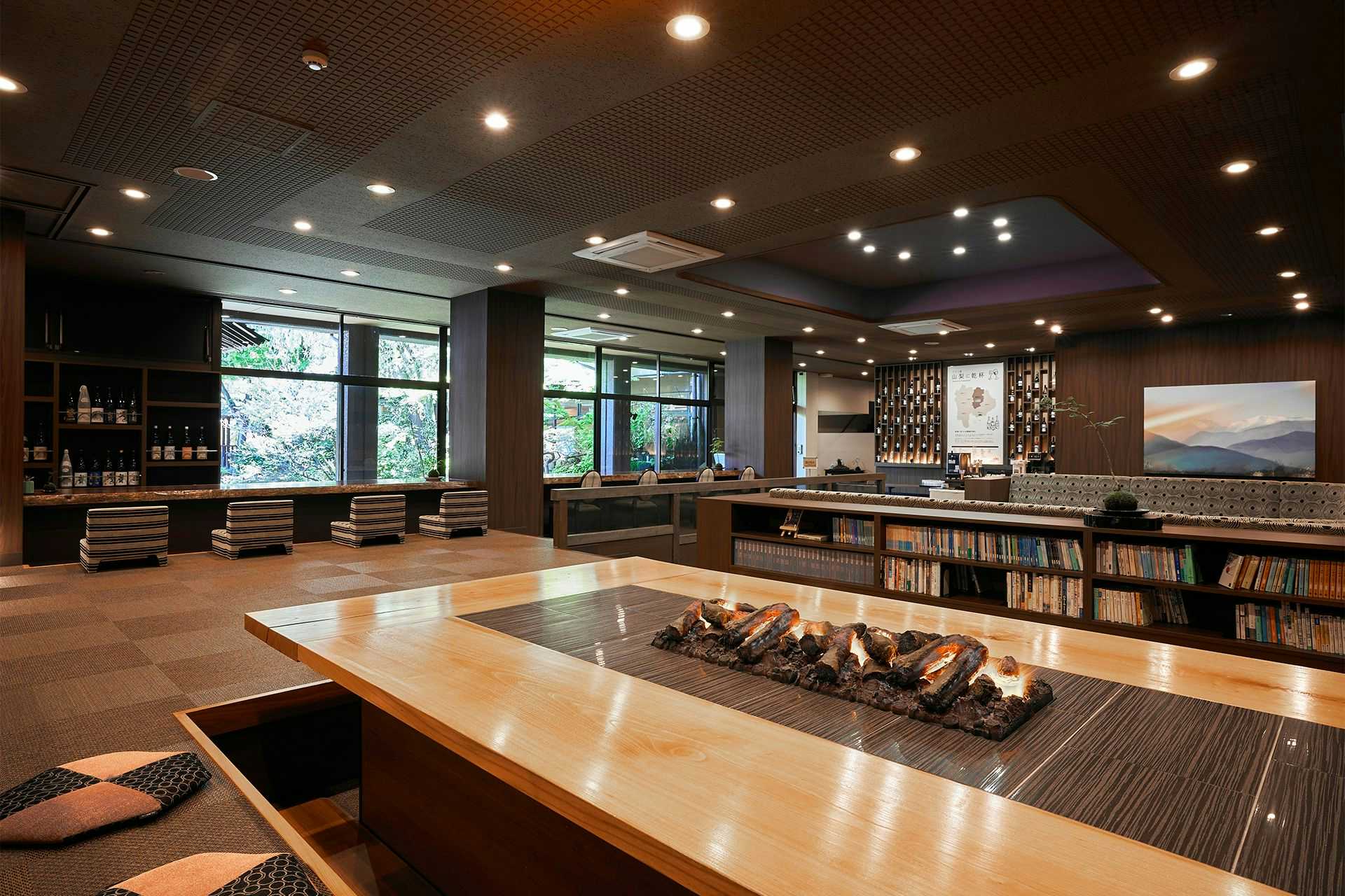 Itoyanagi Koyado Yuwa spacious lounge with a sunken hearth table, library and garden windows