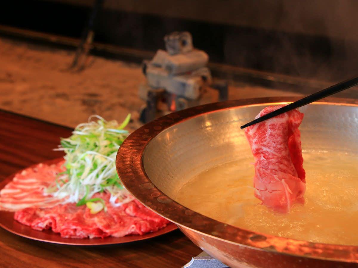 Yamakawa ZENZO utensils lowering a prepared slice into a metal pot.