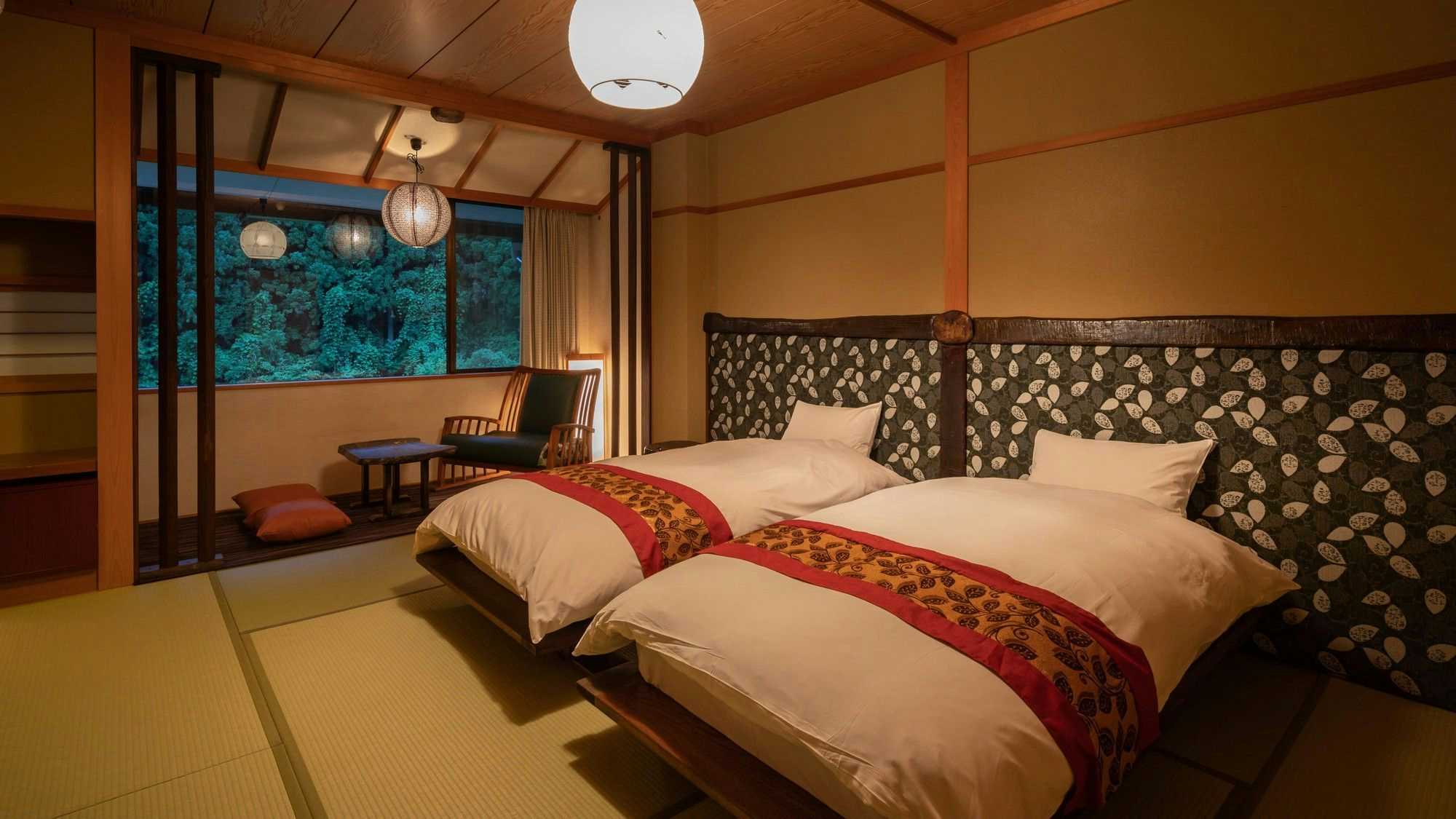 Ryokan Gizan with a warm twin room combining beds and tatami seating.