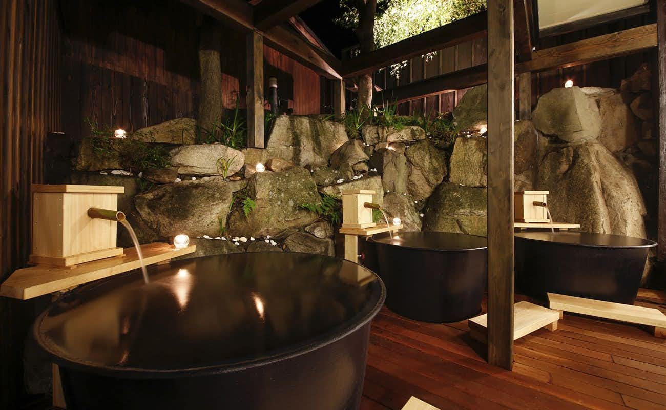 Yubara no Yado Komeya with a private round soaking tub beside natural rock walls.