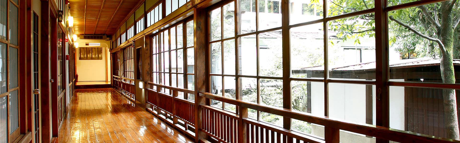 Hitoyoshi Ryokan with a polished timber corridor overlooking the green riverside garden.