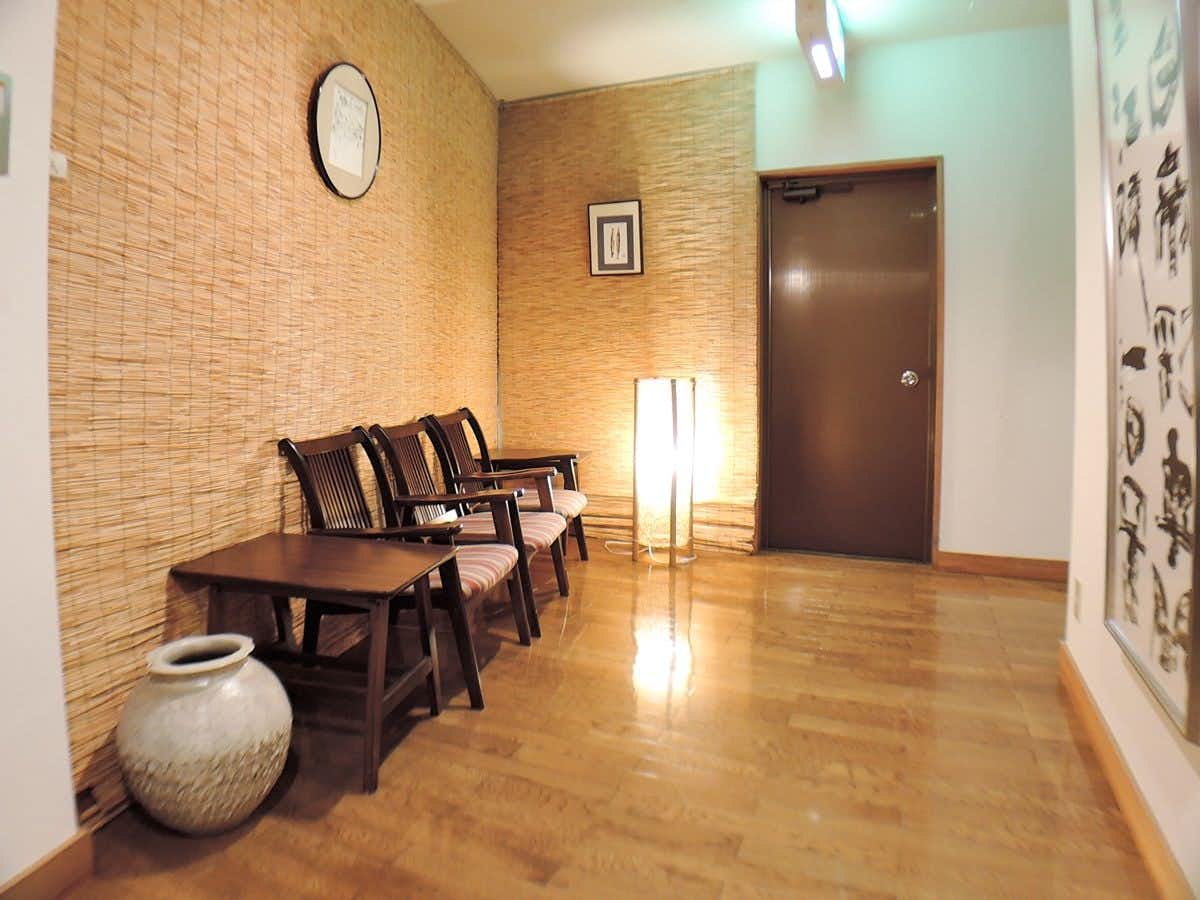 Iimikan Yoshine with a polished corridor with chairs and warm floor lamps.