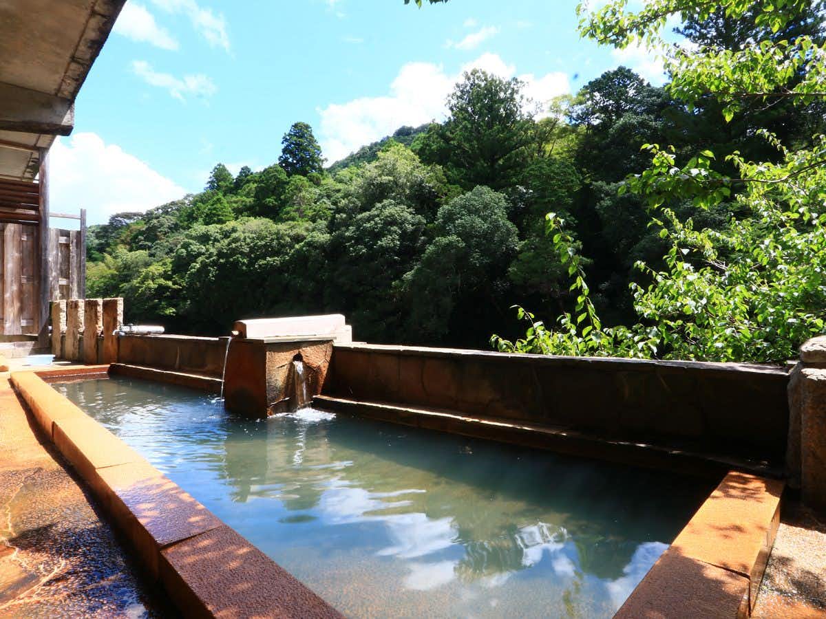 Yuya Onsen Ryosou Mitsui with this scene, where its open-air bath looks across a green riverbank and wooded slope.