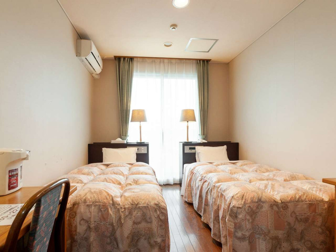 Twin beds beneath a bright window.