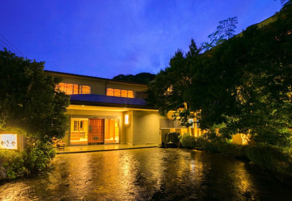 A traditional building illuminated among trees.