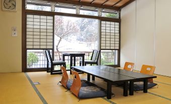 A tatami guest room with a low table and window seating.