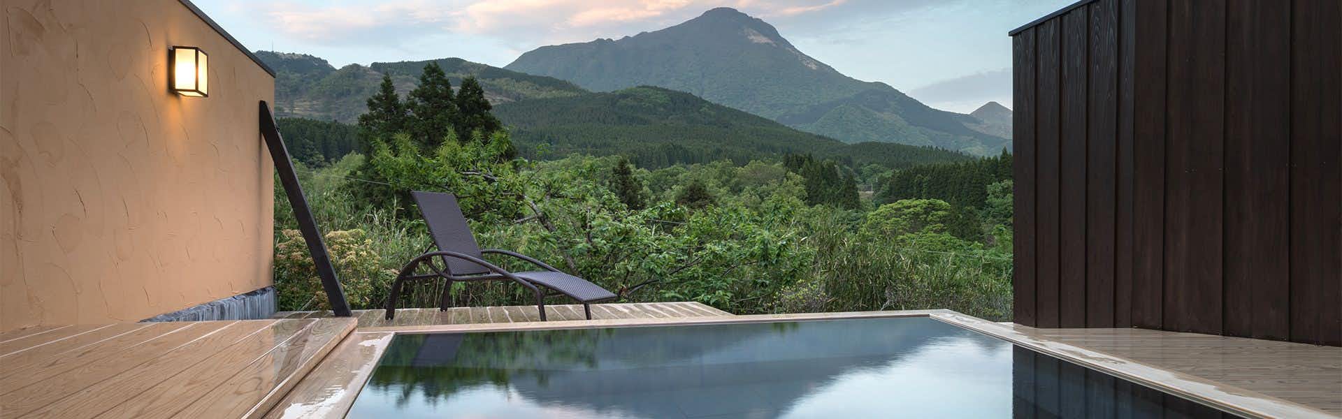 Yufuin Onsen Yutori no Yado Ikkoten with a private outdoor bath overlooking layered mountain peaks.