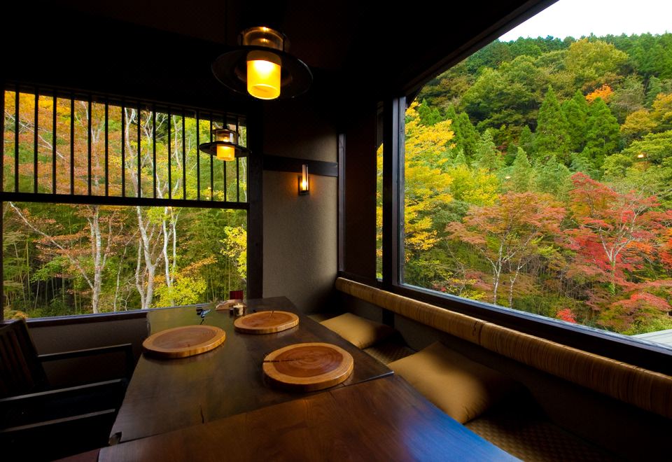 A Japanese dining room overlooking autumn trees.