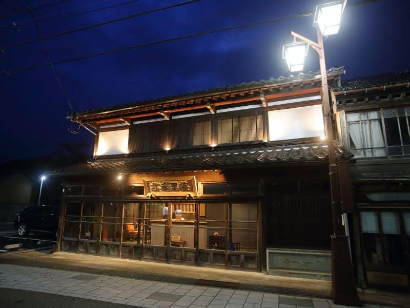 Etchu Inami Machiya Ryokan Kokarian traditional street-facing lodging exterior illuminated at night