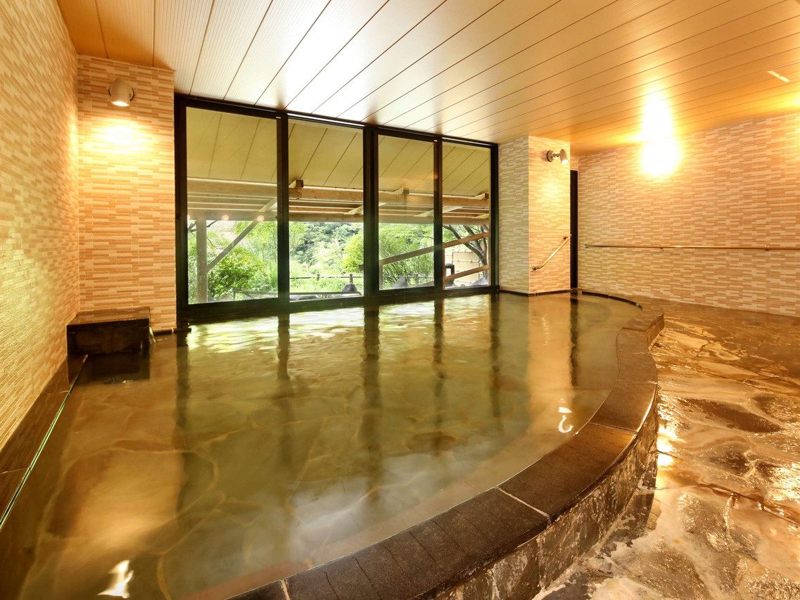 A bright indoor bath combines timber and stone.