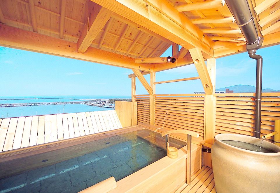 A wooden terrace bath overlooking the sea.