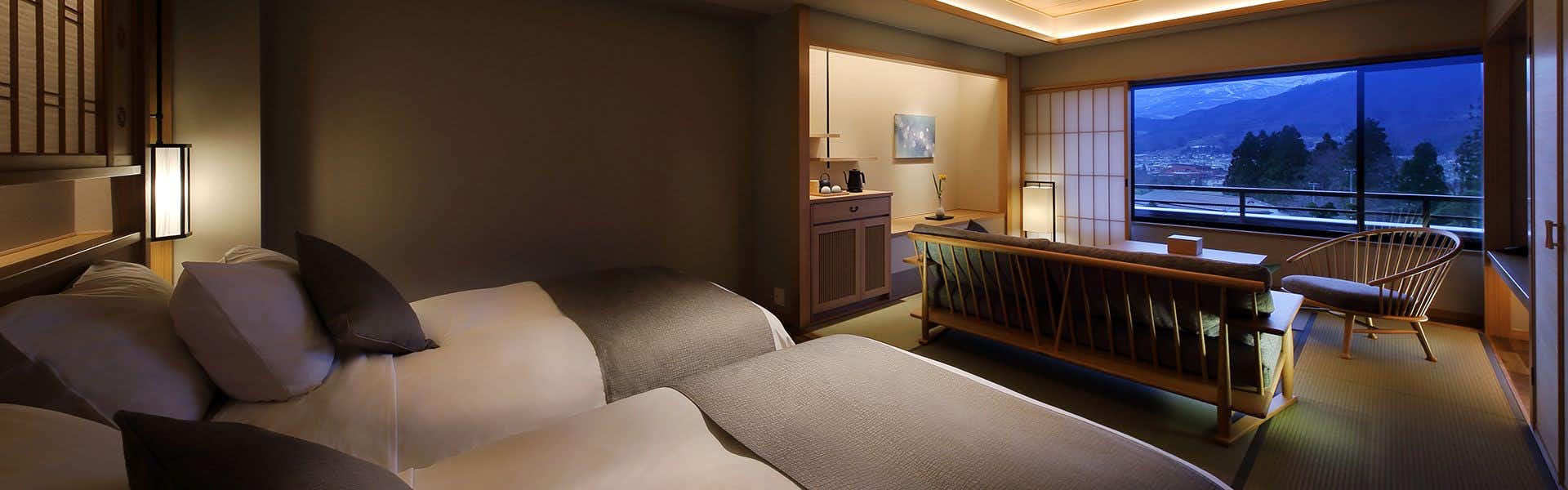 Nippon no Yado Furukama with a modern bedroom opening toward a mountain-view lounge.