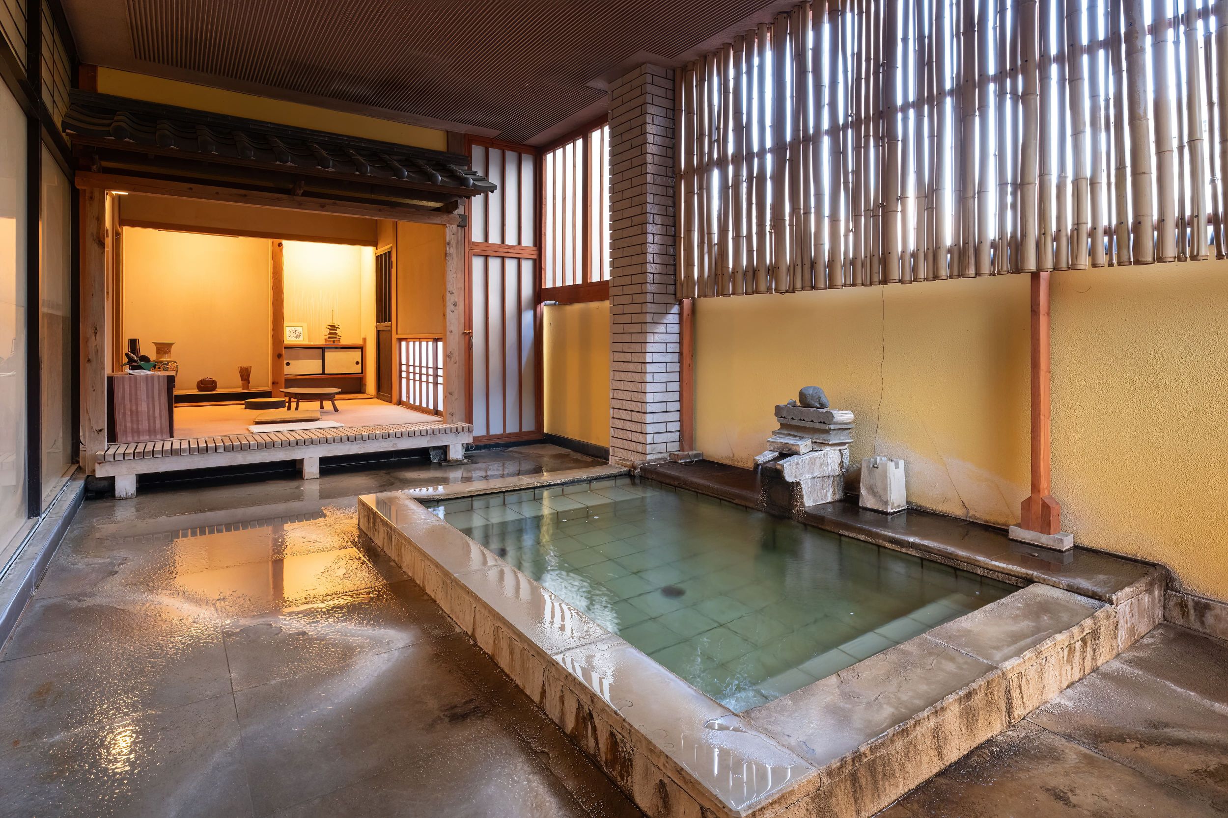 An open-sided bath beside a sheltered guest room.