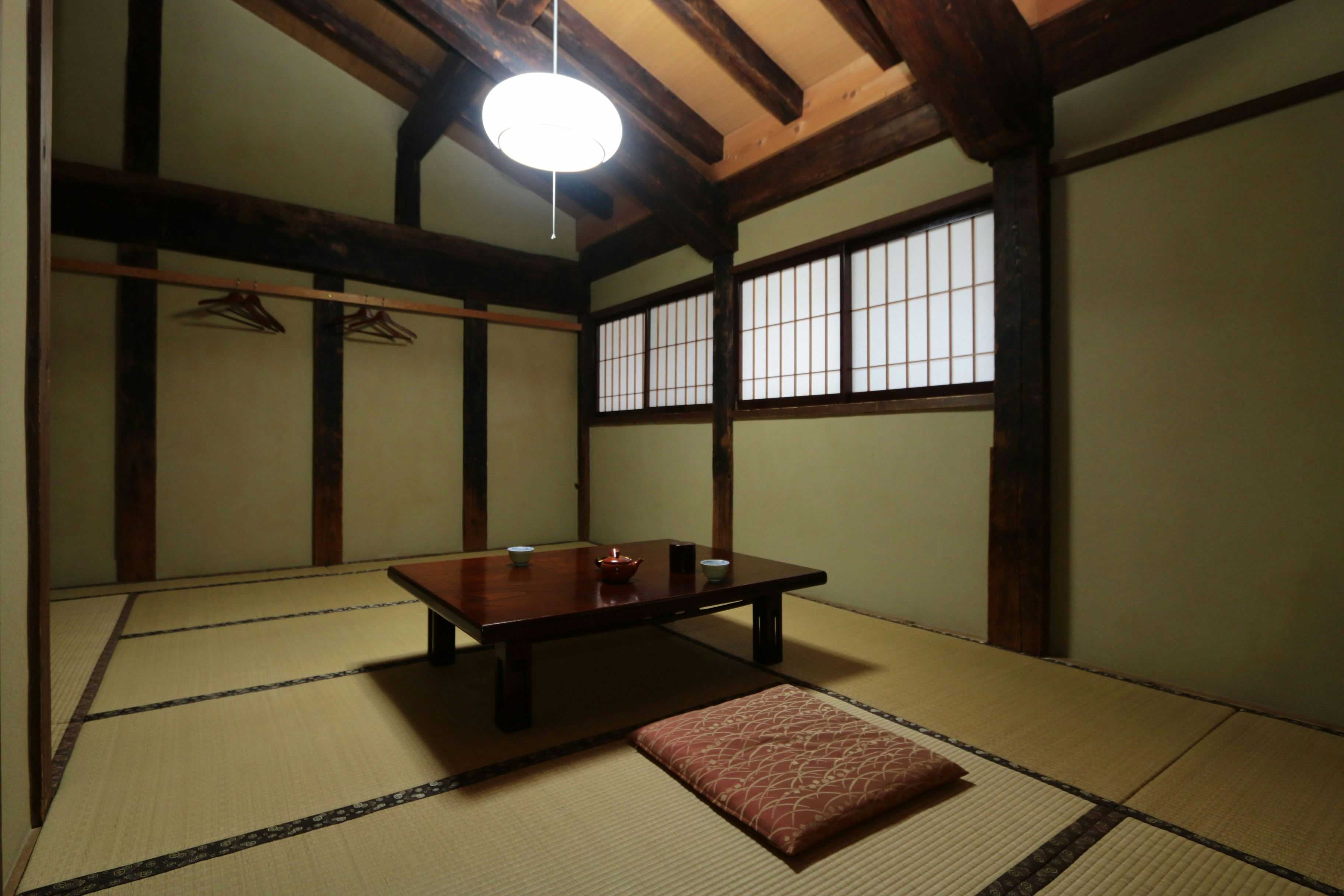 Bokusui-en tatami room with a low table beneath exposed dark beams