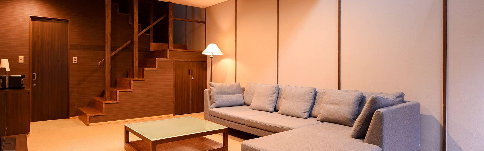 Kotenngu Sanroji with a modern suite with pale sofa and timber staircase.