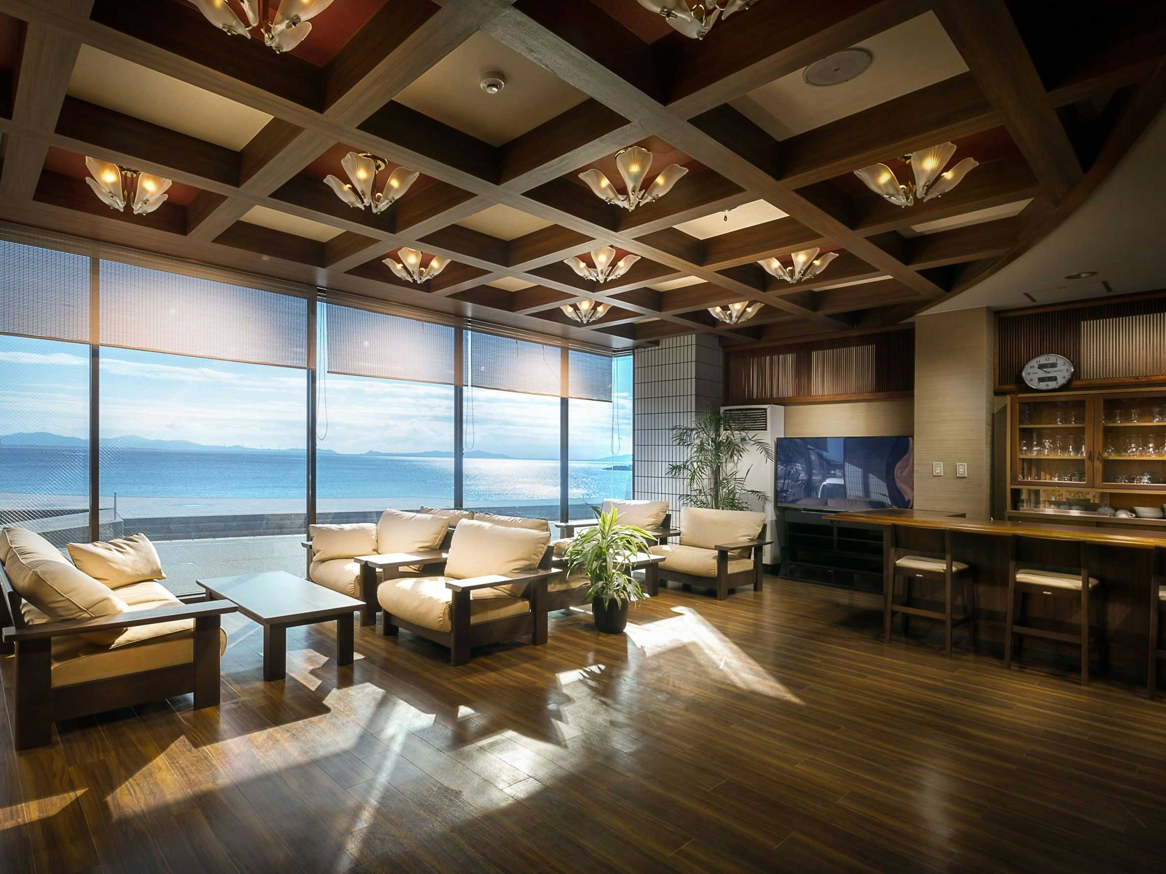 Kousuisou with a panoramic ocean lounge with cream chairs and timber ceiling.