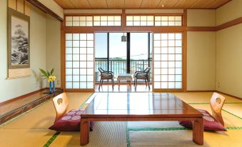A tatami guest room with a low table and window seating.