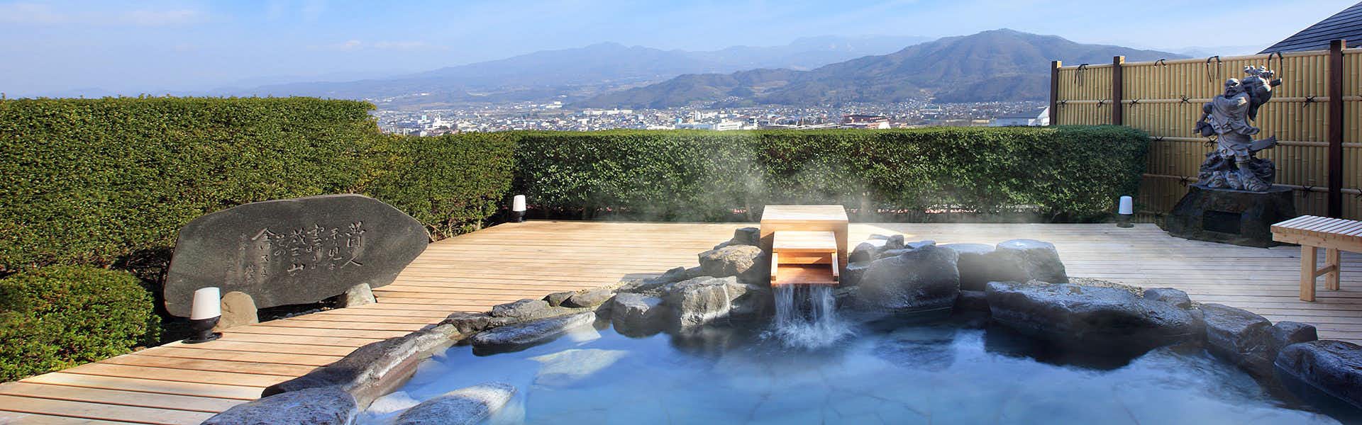 Nippon no Yado Furukama with an outdoor rock bath overlooking distant mountain ridges.