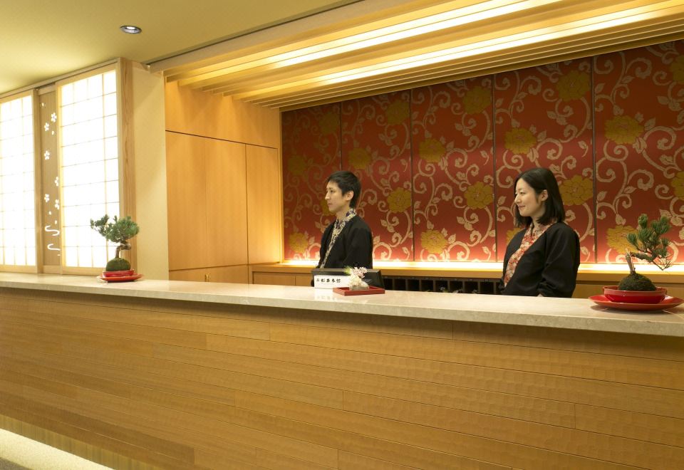 A ryokan reception desk with staff.