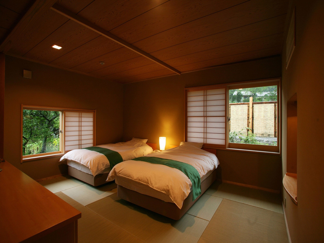 A bedroom with twin beds and a window.