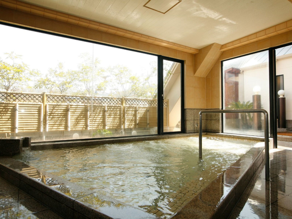 Indoor bath beside a wooden screen.