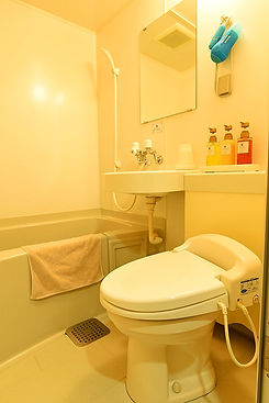 Compact unit bathroom with a bathtub, sink and toilet.