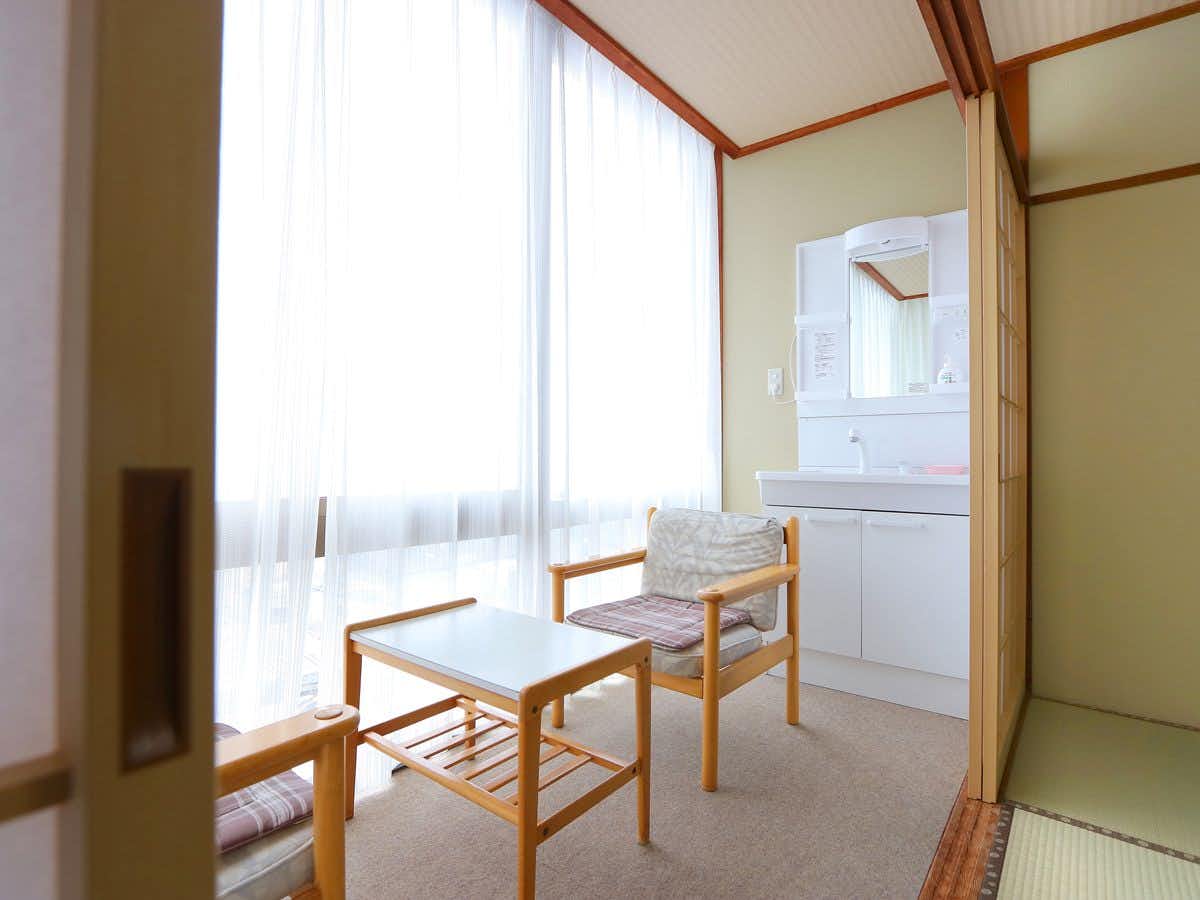 Ginkai with a compact sitting area with two pale wooden chairs.