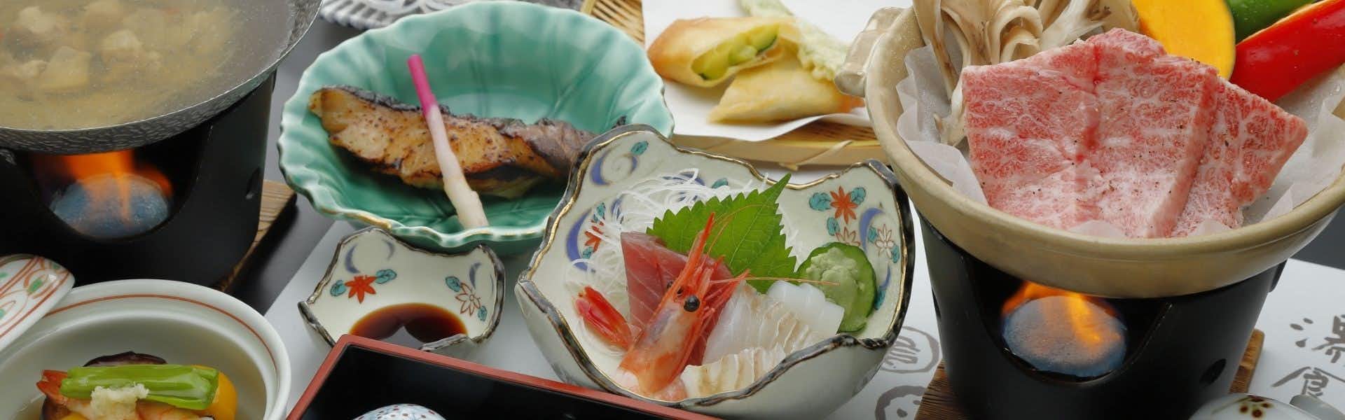 Ryokan Oonuma Sliced raw fish with white garnish and red accent elements on a scalloped white plate.