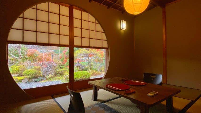 A small traditional Japanese-style accommodation, Culinary Ryokan Sushi Yone with a private dining room overlooking a manicured garden.