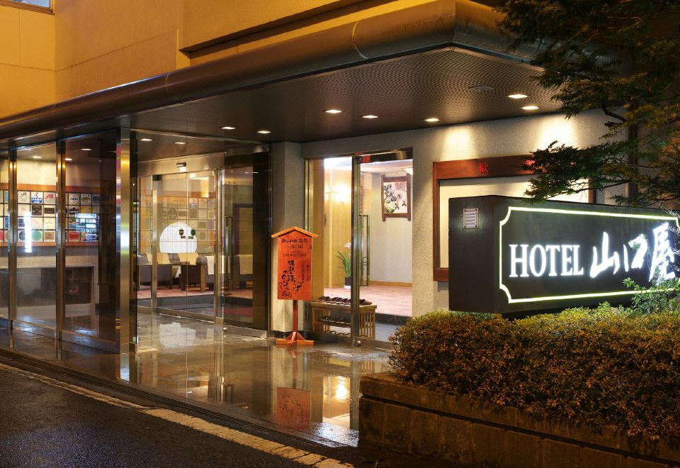 A hotel entrance with a lit sign.