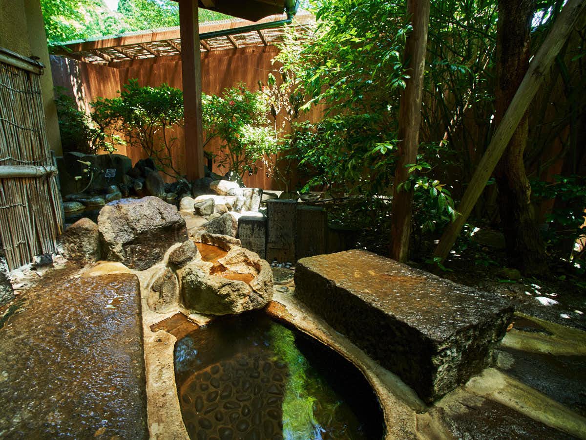 Hanare Yado Yamazaki with a secluded outdoor stone bath beneath dense leafy trees.