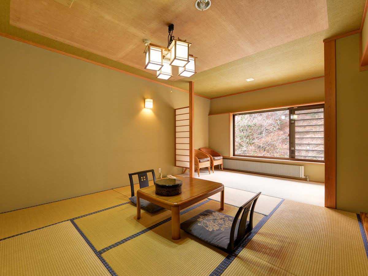 Kawako Onsen Hamaya Ryokan with a calm tatami room with low table and broad window.