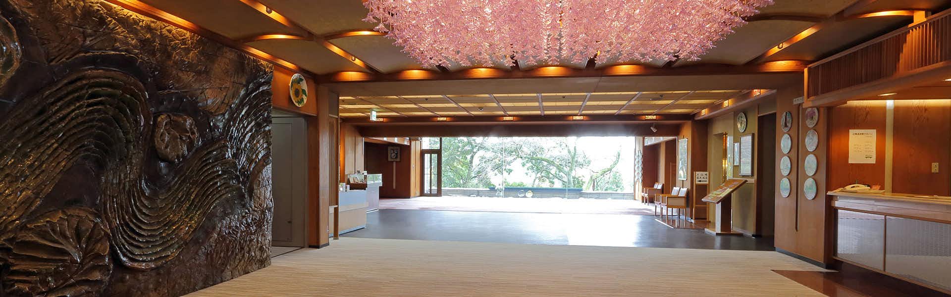 Yunoyado Hakusan Shobutei with this scene, where a blossom-lit lobby corridor leads toward a bright window at the far end.