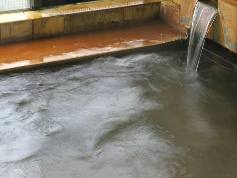 Kansei Onsen Tomiya Ryokan with mineral water flowing into a natural stone bath.