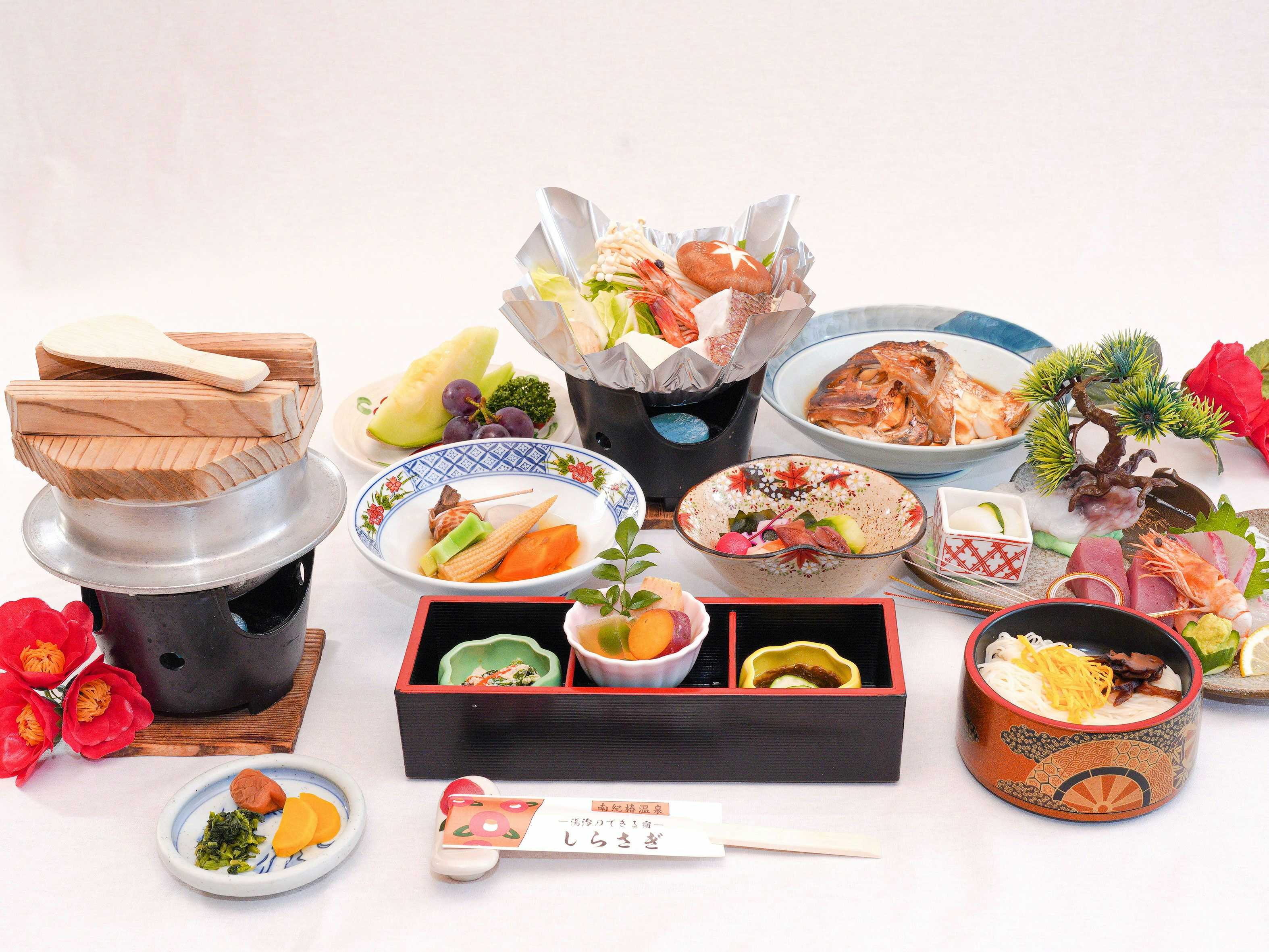 Nanki Shirahama Tsubaki Onsen Healing Inn Shirasagi with a generous Japanese dinner arranged across colorful tableware.