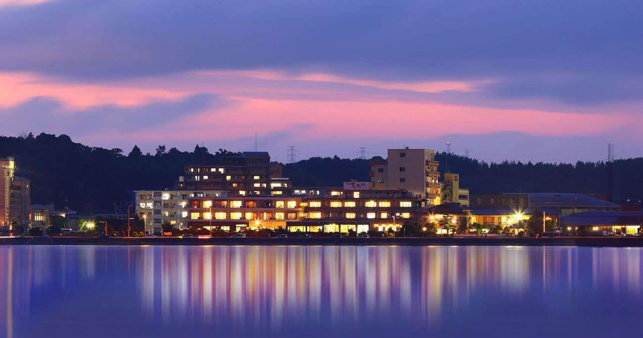 Matsue Shinji Lake Onsen Sunset Lakeside Suitenkaku with the illuminated ryokan reflected across Lake Shinji at sunset.