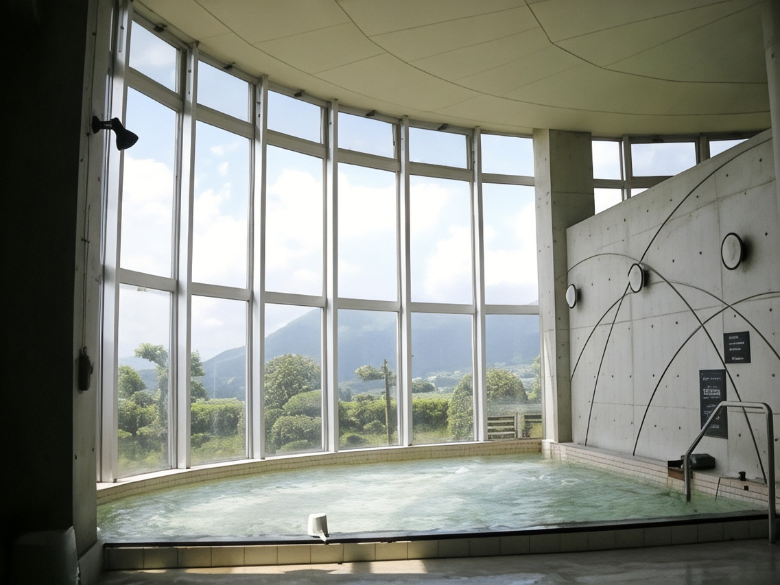 Curved indoor bath beside a wall of windows.
