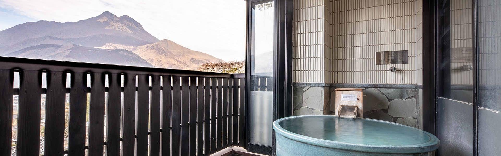 Bisei: Inn with a View of Mount Yufu with a private round bath overlooking Mount Yufu through timber screens.