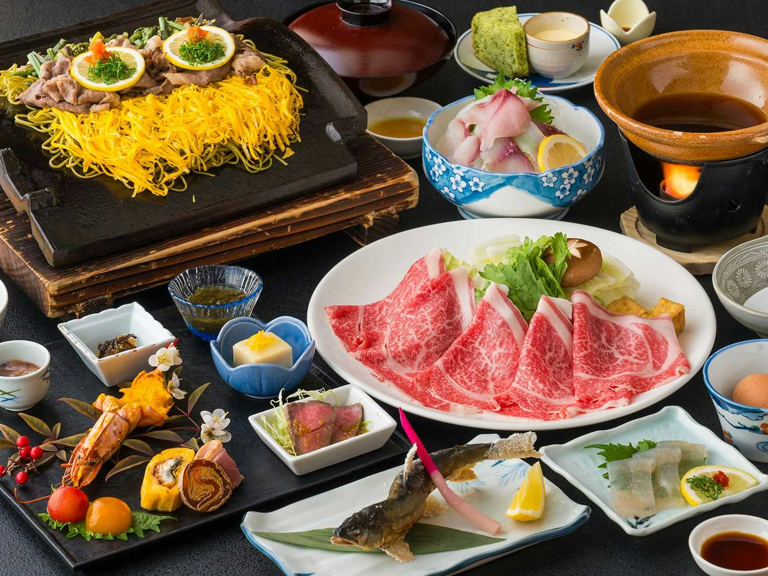Furuyu Onsen Ougiya Ryokan with a seasonal Japanese dinner arranged across colorful lacquerware.
