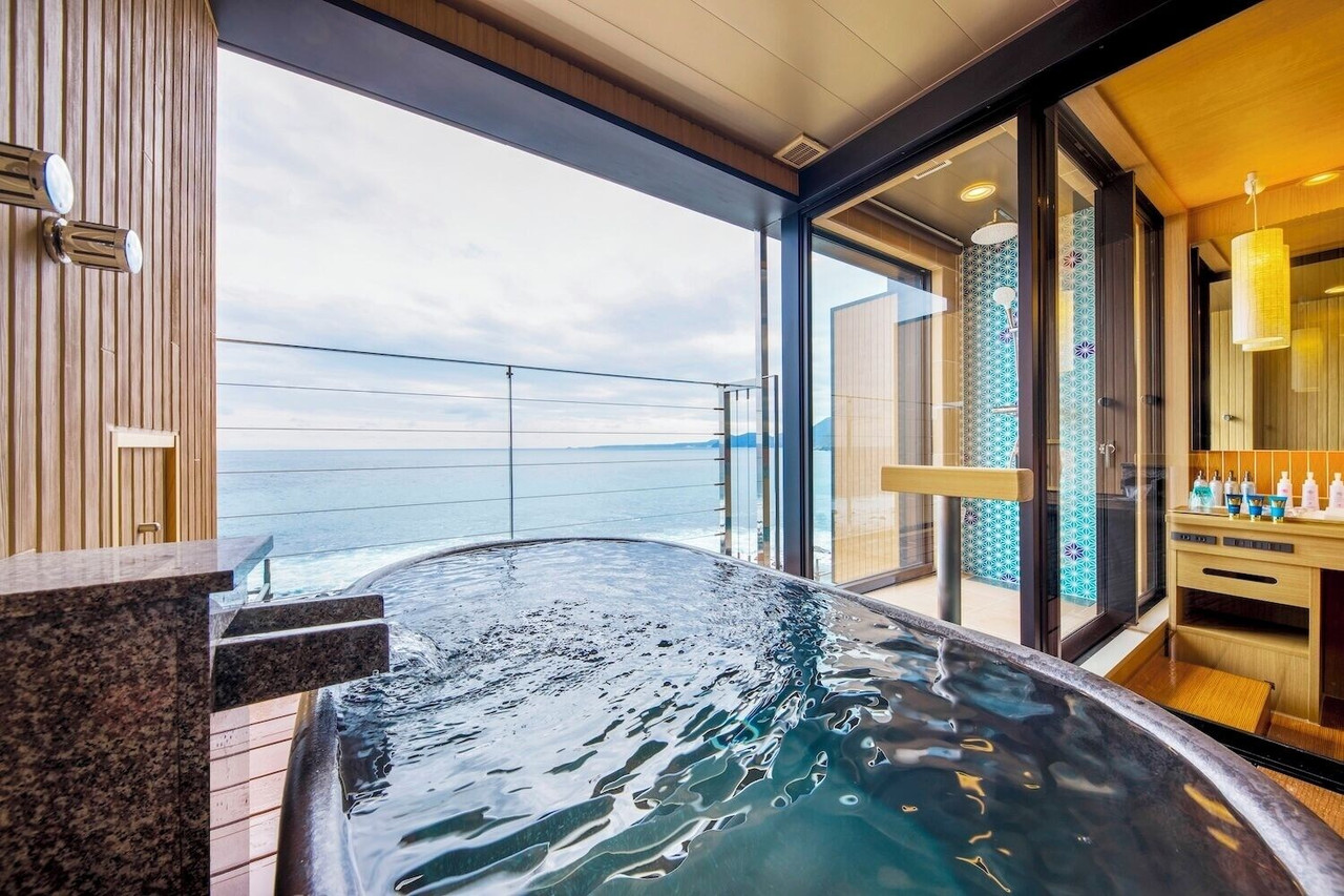 Open-air bath beside a glass wall.