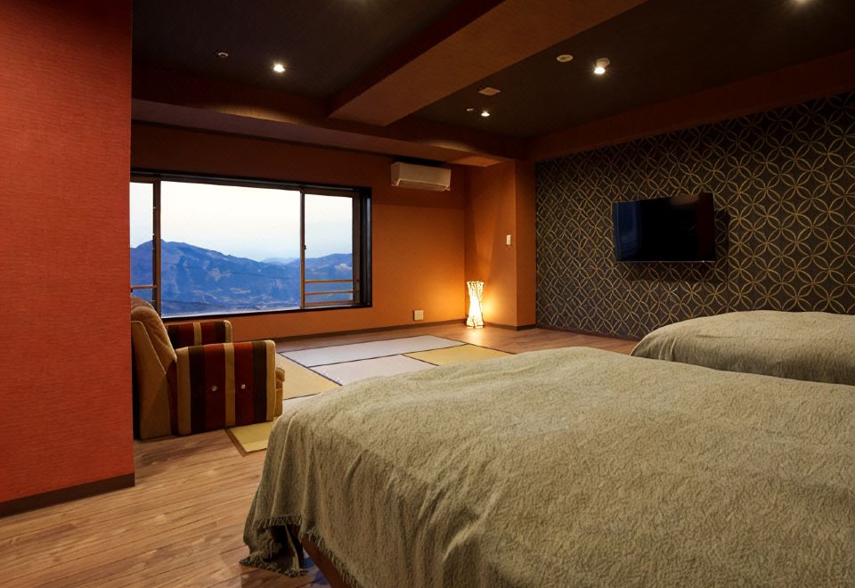 A guest room with beds and a mountain view.