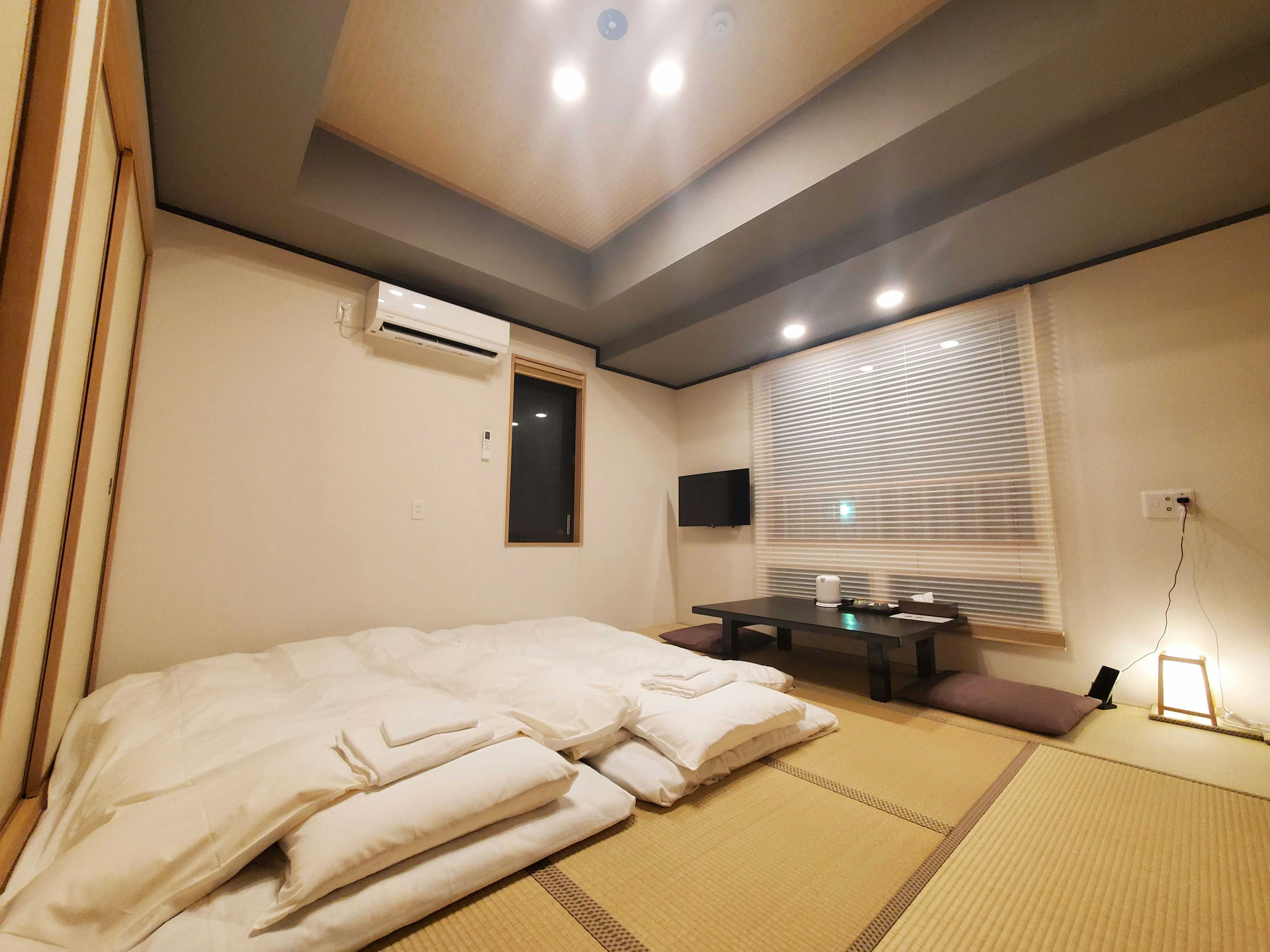 Ryokan Kintou with a tatami guest room prepared with several white futons.