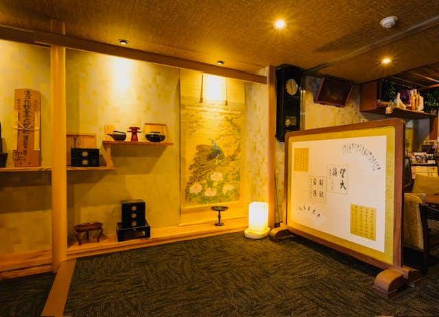 Fukumakan with a warm lobby displaying ceramics and framed artwork.